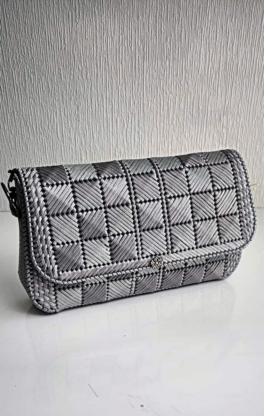 Handgefertigte Schultertasche „Cecília“ – Silbergrau 
Einzigartige Flechtkunst trifft auf modernes Design. Die handgefertigte Tasche „Cecília“ aus robustem Canvas besticht durch ihr silbergraues Schachbrettmuster, zwei sichere Magnetverschlüsse und eine edle, schwarze Gliederkette. Der perfekte Begleiter im Hochformat für Ihre wichtigsten Essentials.