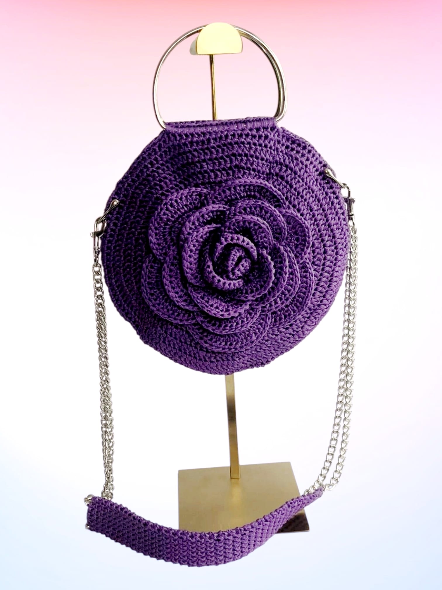 Gehäkelte runde Handtasche Violetta in Lila mit 3D-Rose auf Ständer