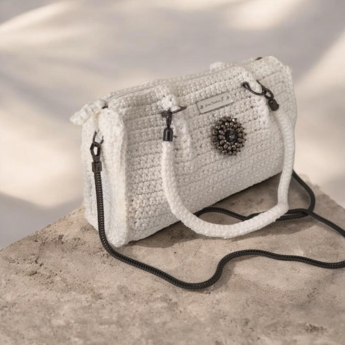  Handgefertigte Eleganz in purem Weiß.
Diese edle Häkeltasche ist ein absoluter Blickfang und vereint moderne Handwerkskunst mit luxuriösen Details. Gehäkelt aus hochwertigem Polyester-Garn, besticht die Tasche durch ihr dichtes, strukturiertes Maschenbild. Das Material sorgt dafür, dass die Tasche besonders formstabil, strapazierfähig und langlebig bleibt.

